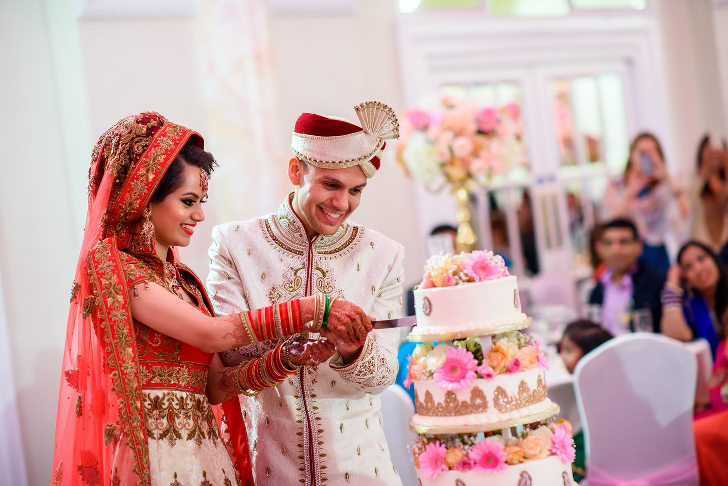 Traditional wedding ceremony with cake and decorations in an elegant white venue.