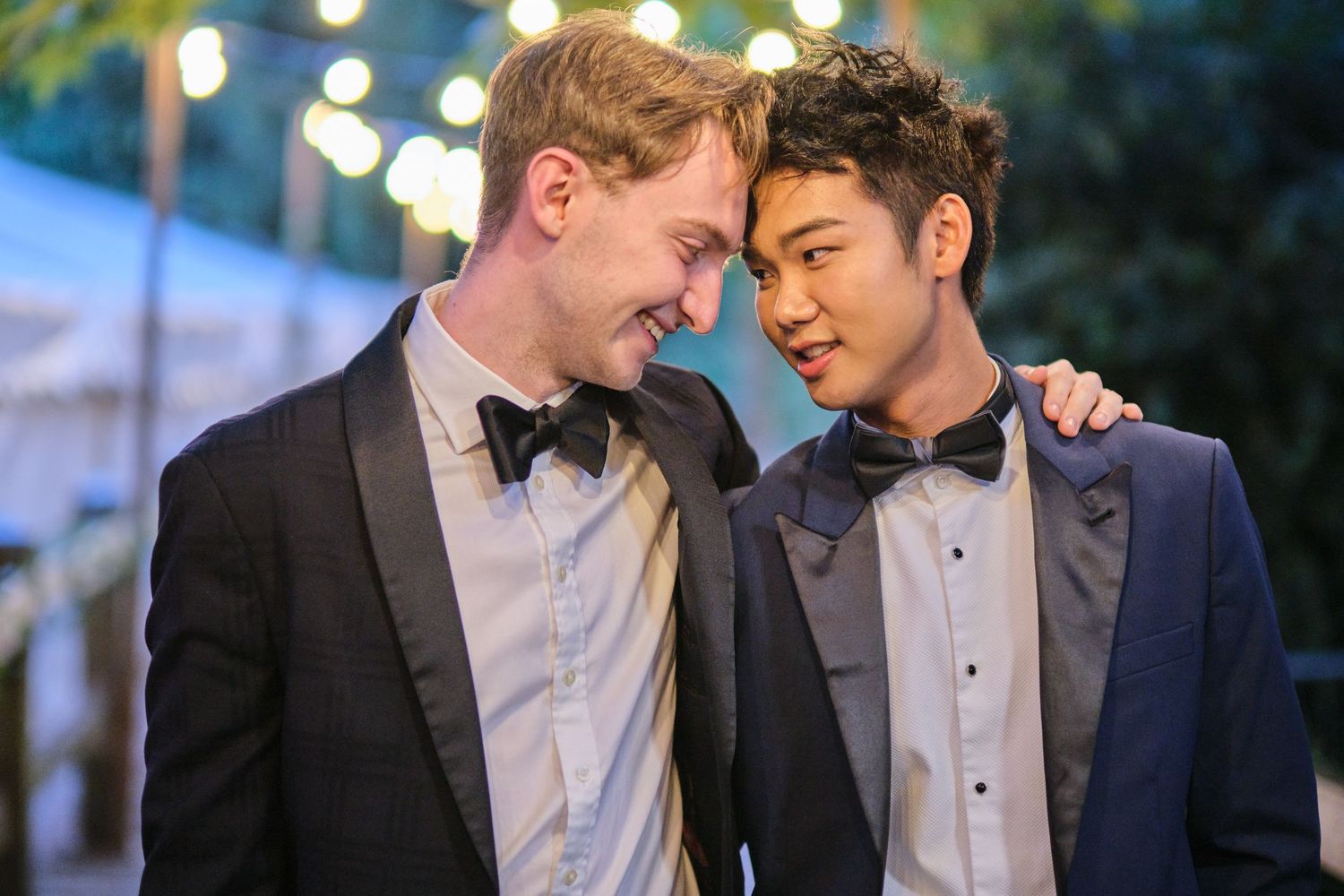 Romantic evening gathering under twinkling string lights at an outdoor event space.