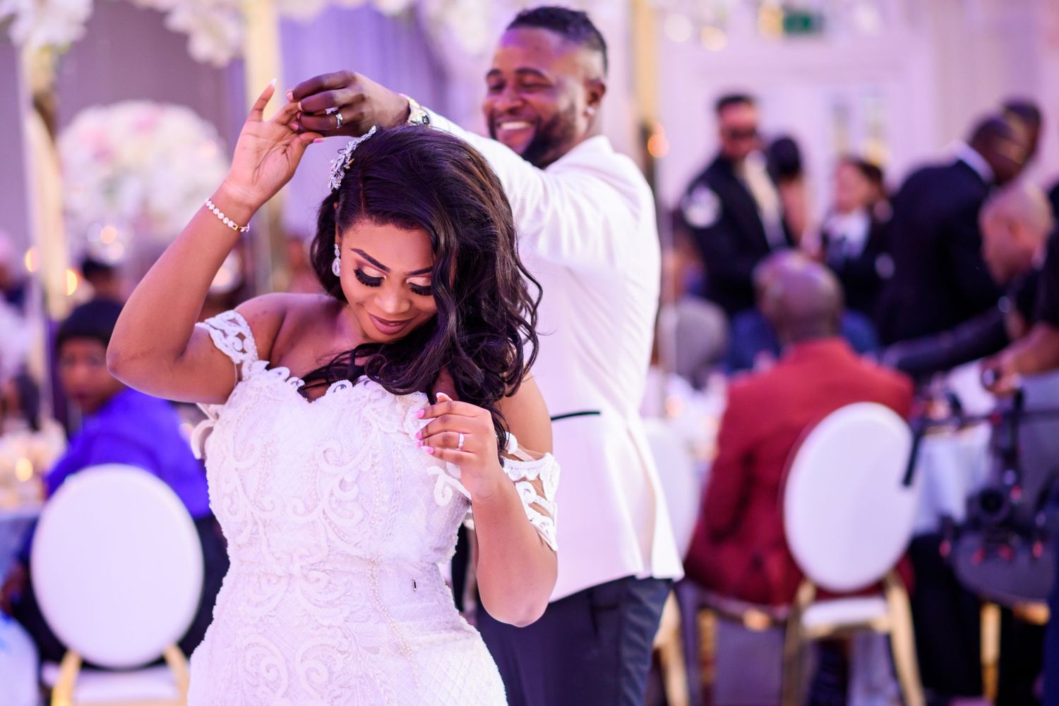 Wedding reception venue decorated with purple lighting and elegant white decor.
