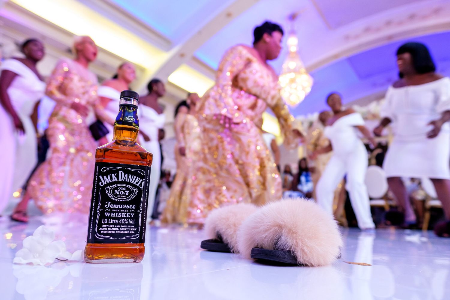 Wedding reception details with Jack Daniels bottles and pink lighting effects.