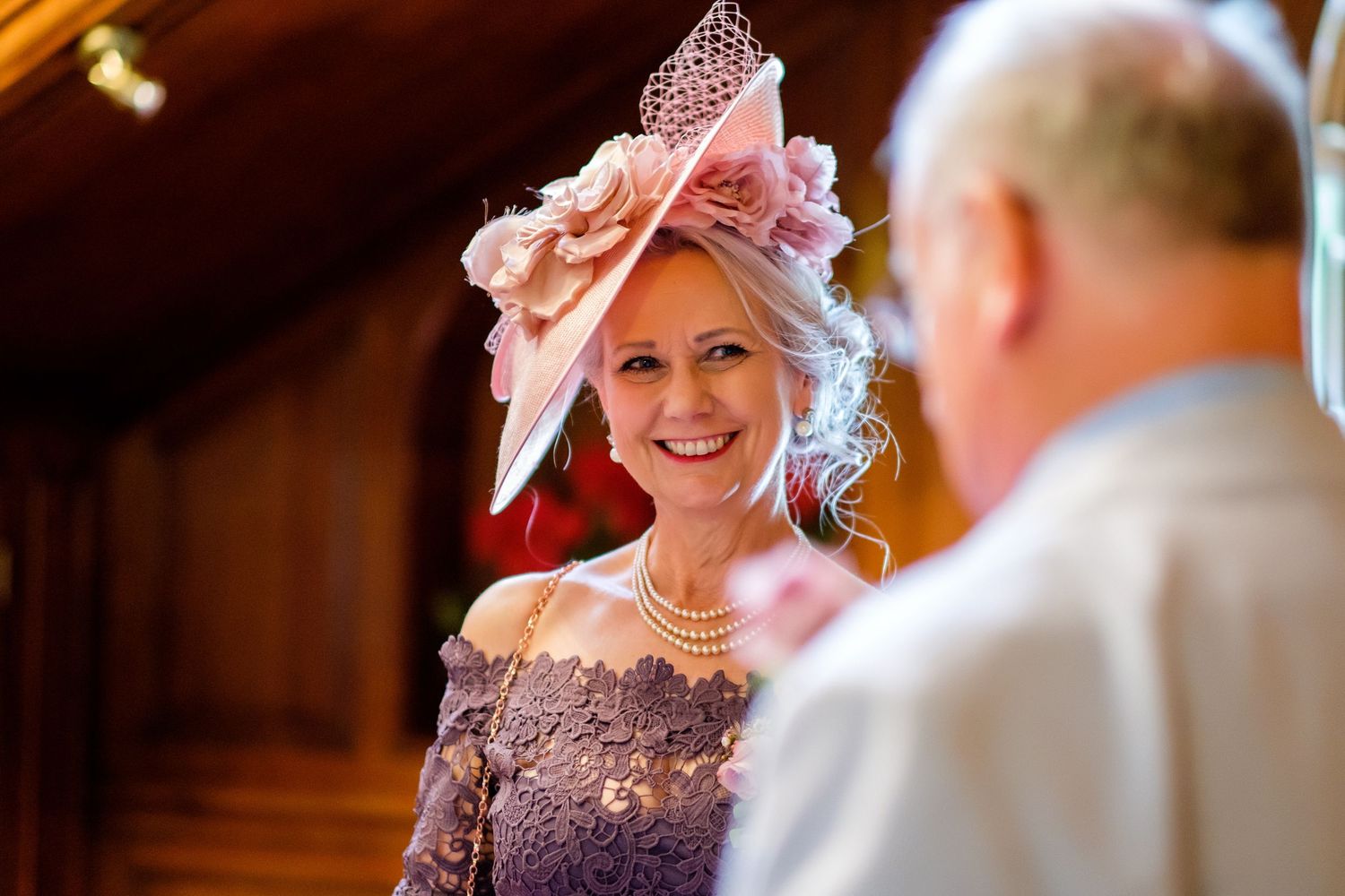Wedding guests share intimate conversations in a warm-lit indoor setting.