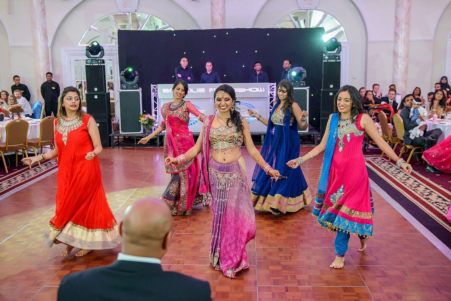 Dancers in colorful traditional Indian attire perform at a festive celebration.