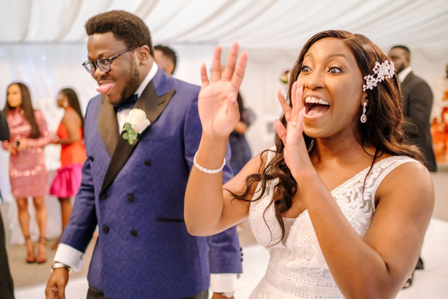 Wedding reception guests smiling and dancing together in formal attire.