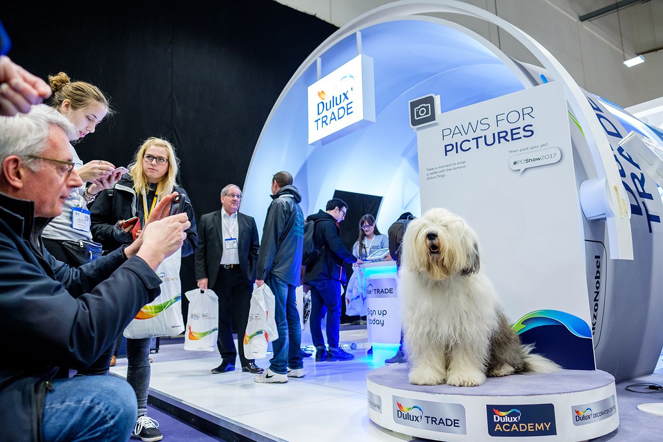 Exhibition space with curved white displays and technology demonstrations at a trade show.