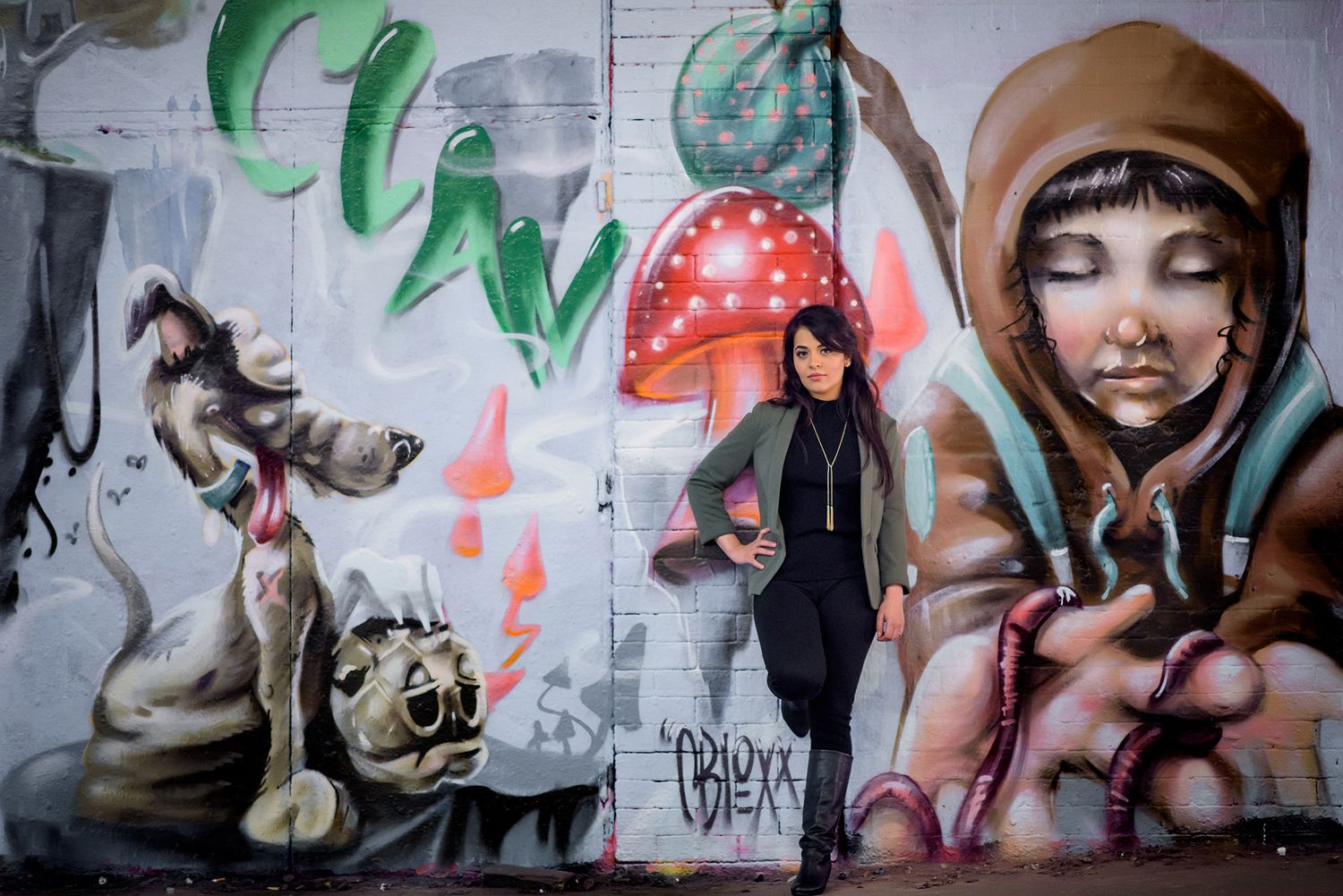 Urban graffiti art mural featuring green and red designs on a white wall.