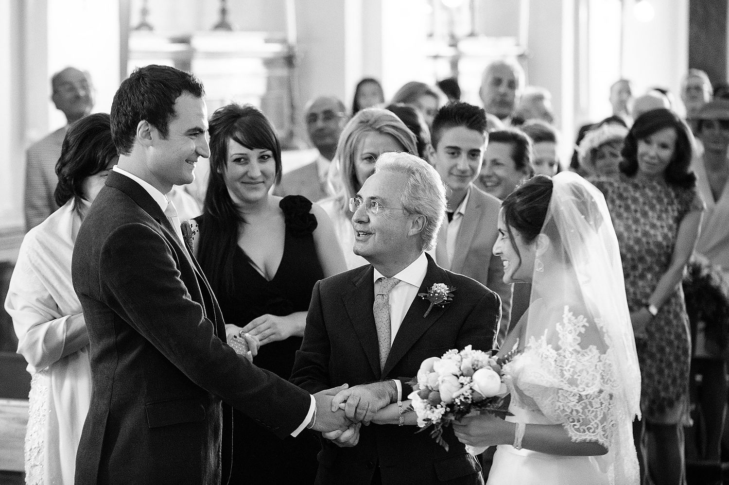 Wedding ceremony processional in a traditional church with ornate architecture.
