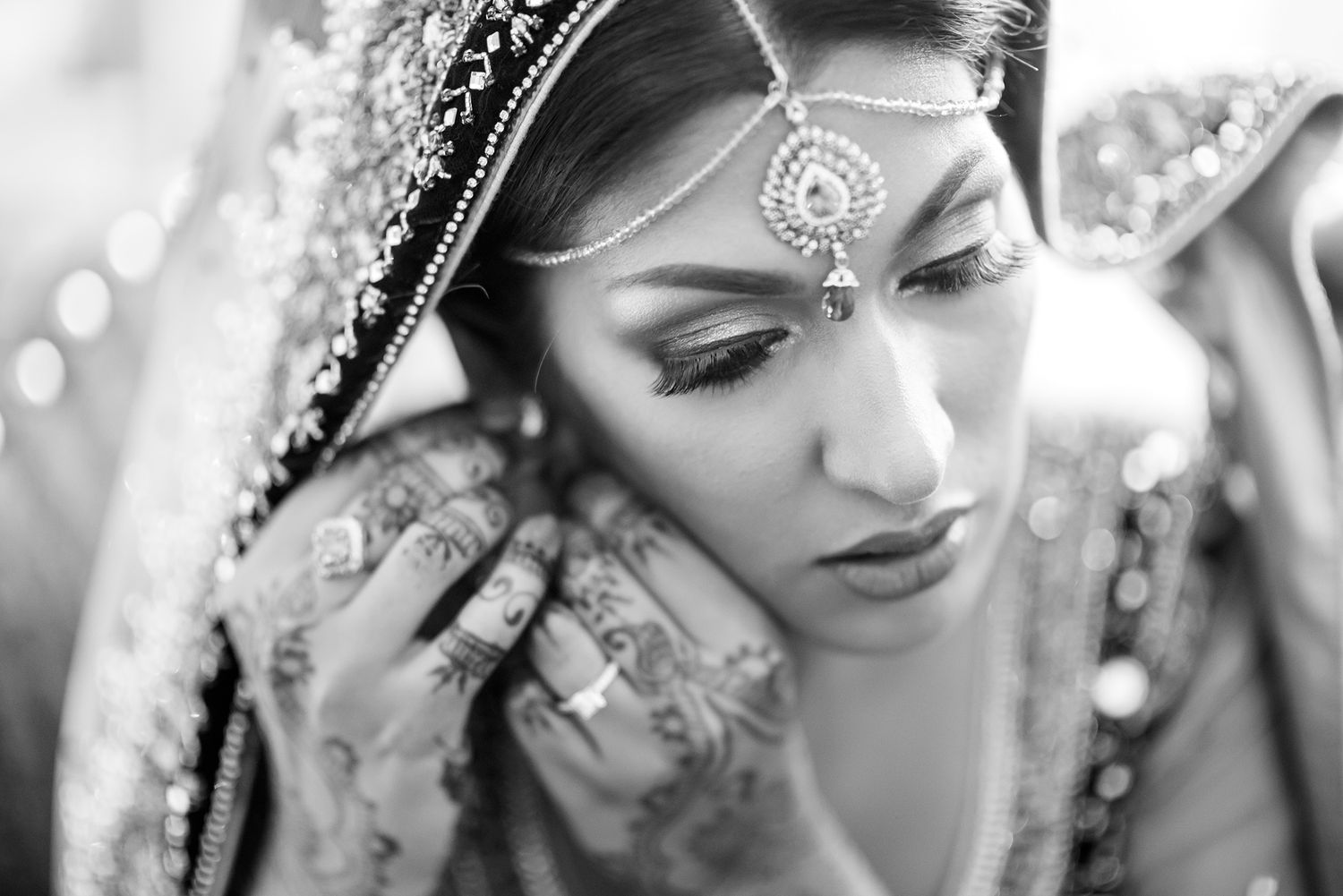 Black and white close-up of traditional Indian bridal jewelry and makeup details.