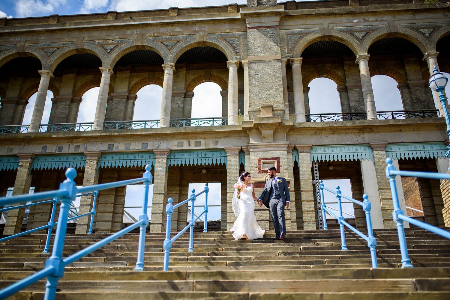 Historic stone building with arched colonnade decorated with blue ribbons for a wedding ceremony.
