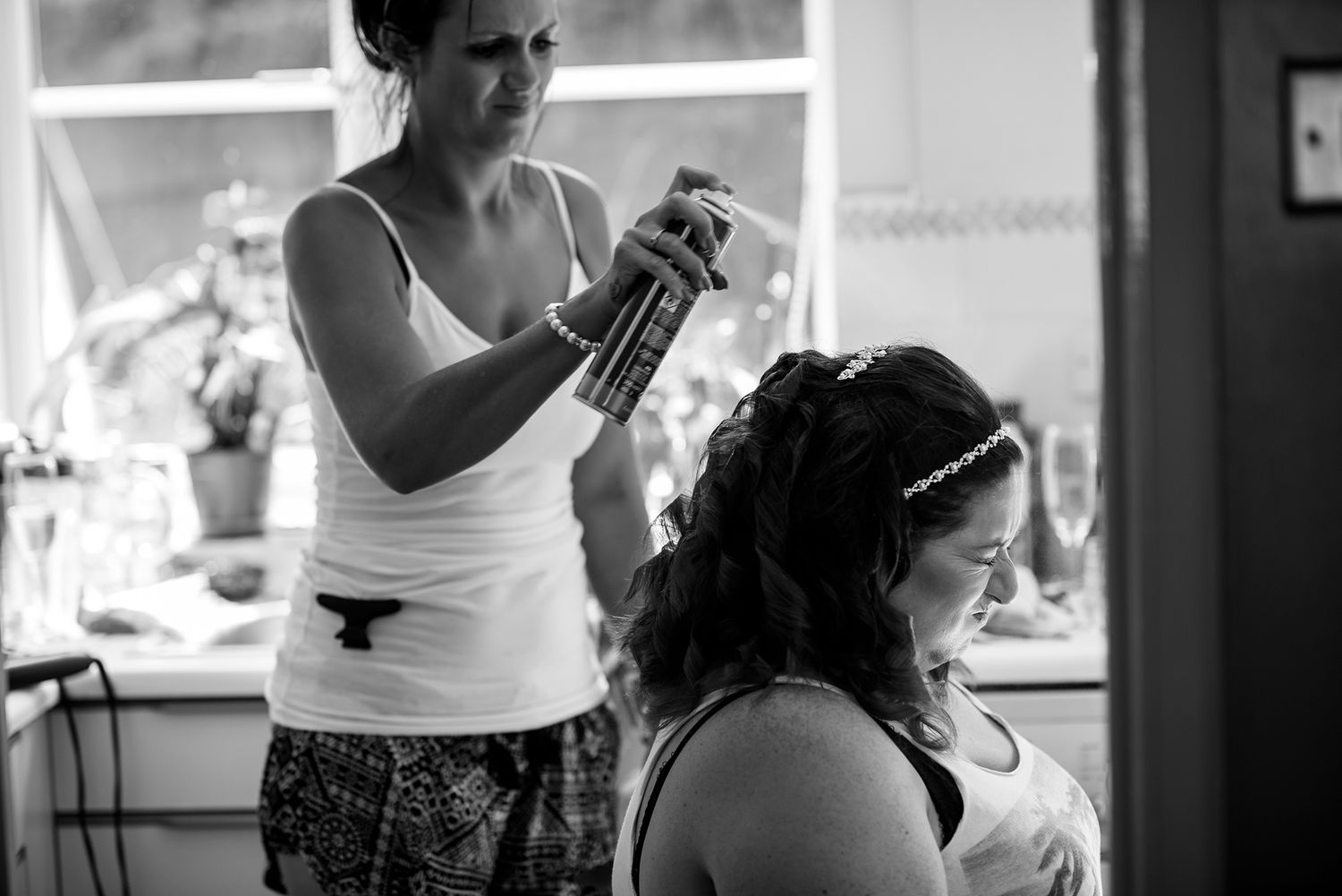 Black and white candid shot of people preparing in a kitchen.