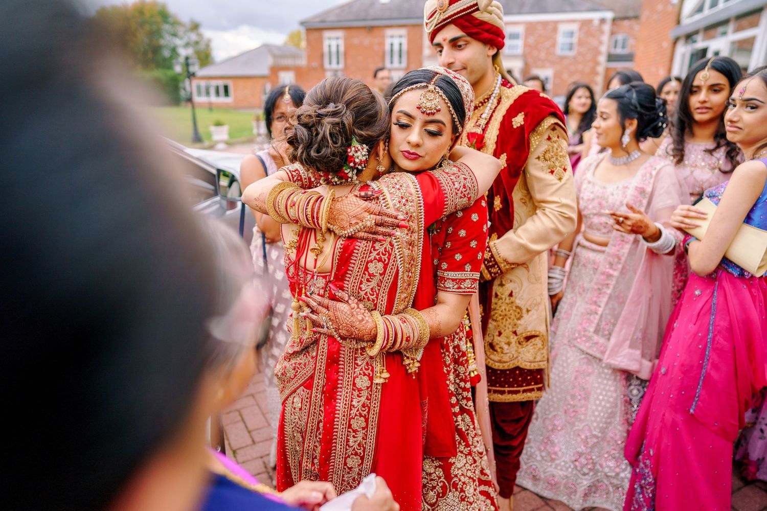 Outdoor wedding gathering with guests in colorful traditional Indian and Western attire.