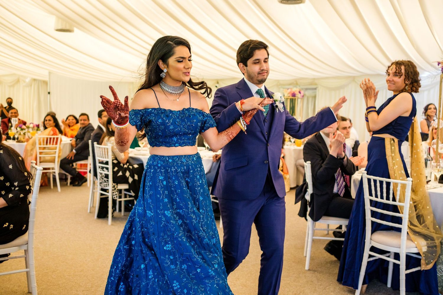 Wedding reception in an elegant white tent with couples dancing on the dance floor.