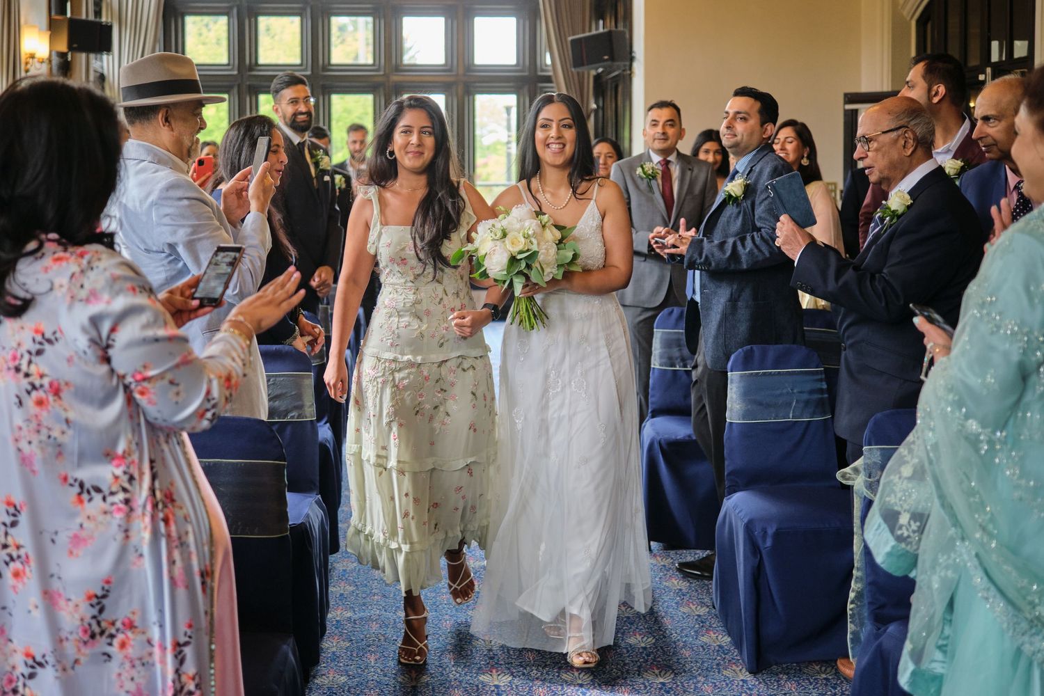 Wedding ceremony guests seated in rows at an elegant indoor venue.
