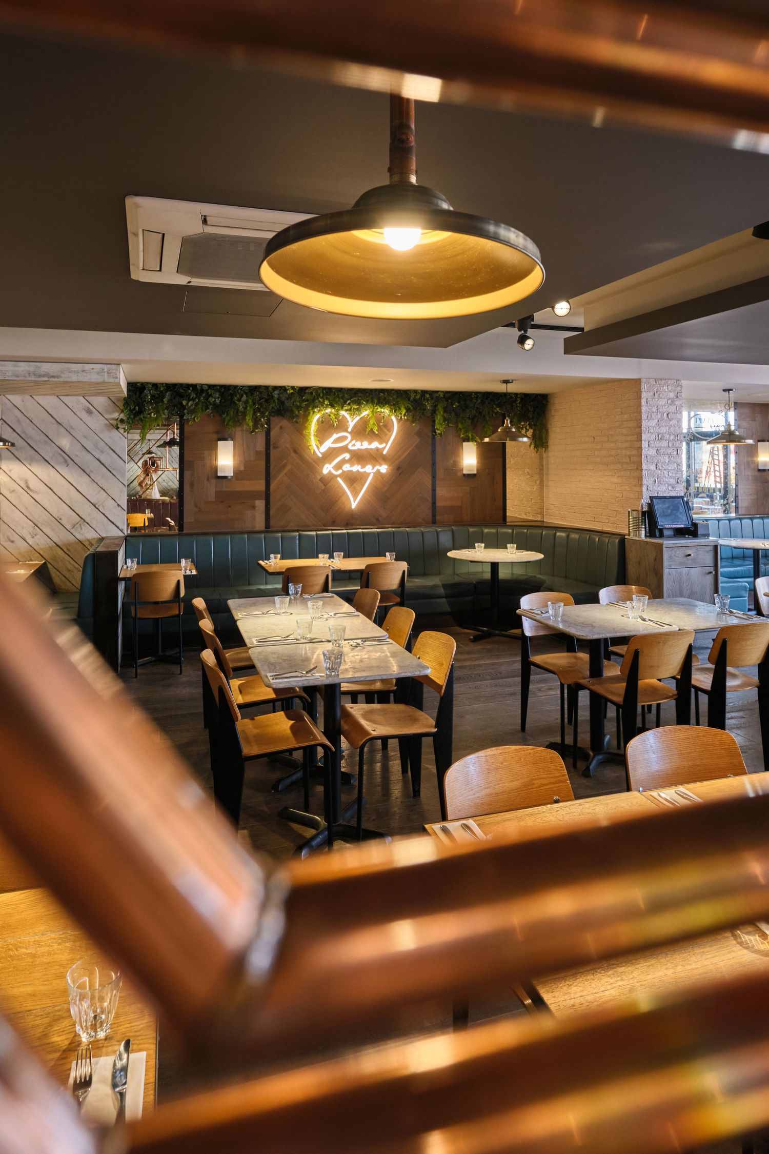 Modern restaurant interior with warm lighting and comfortable seating arrangements showcases elegant dining atmosphere.