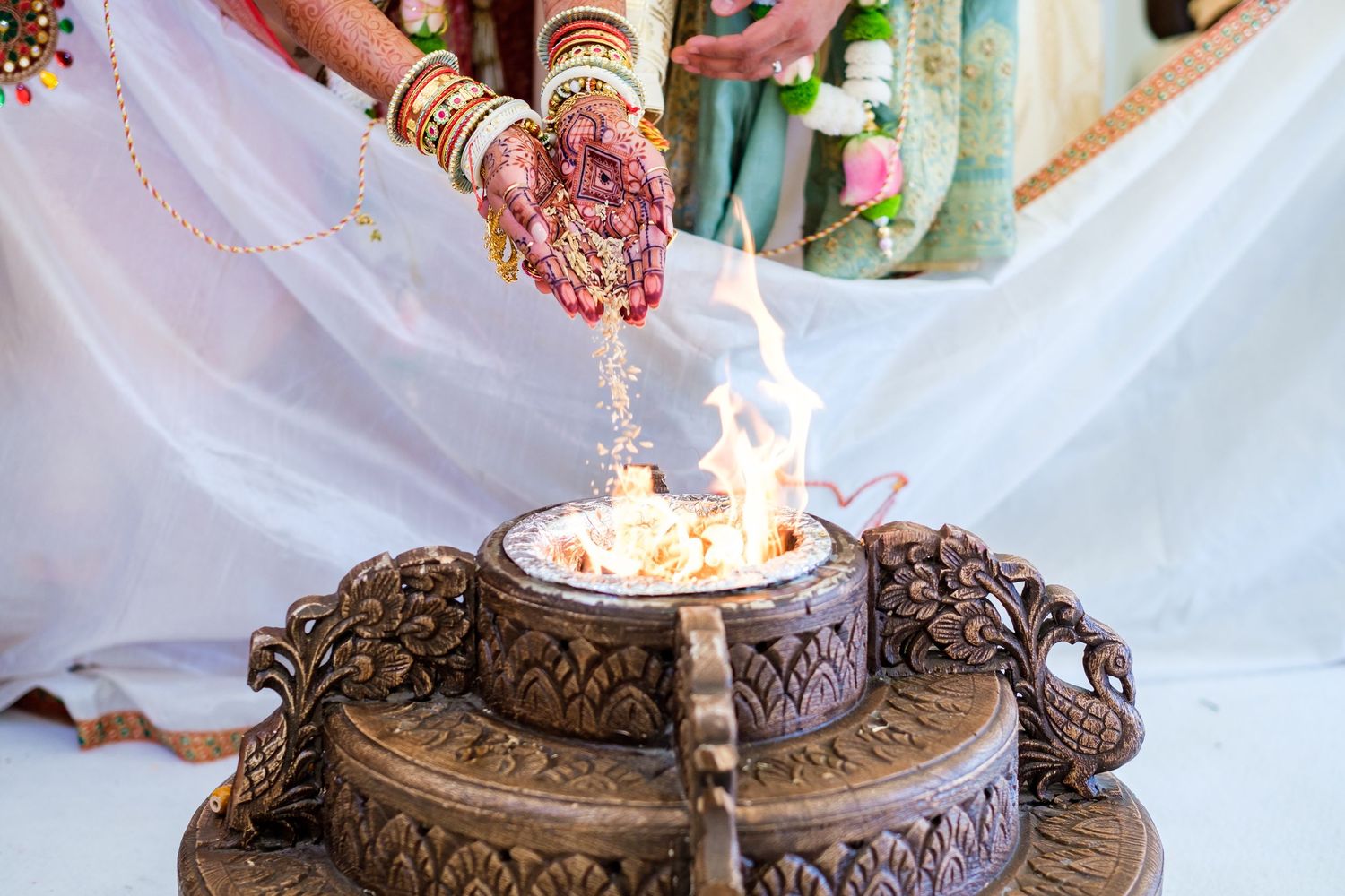 Ornate bronze ceremonial plate with candles and decorative details displayed at a traditional Indian wedding.