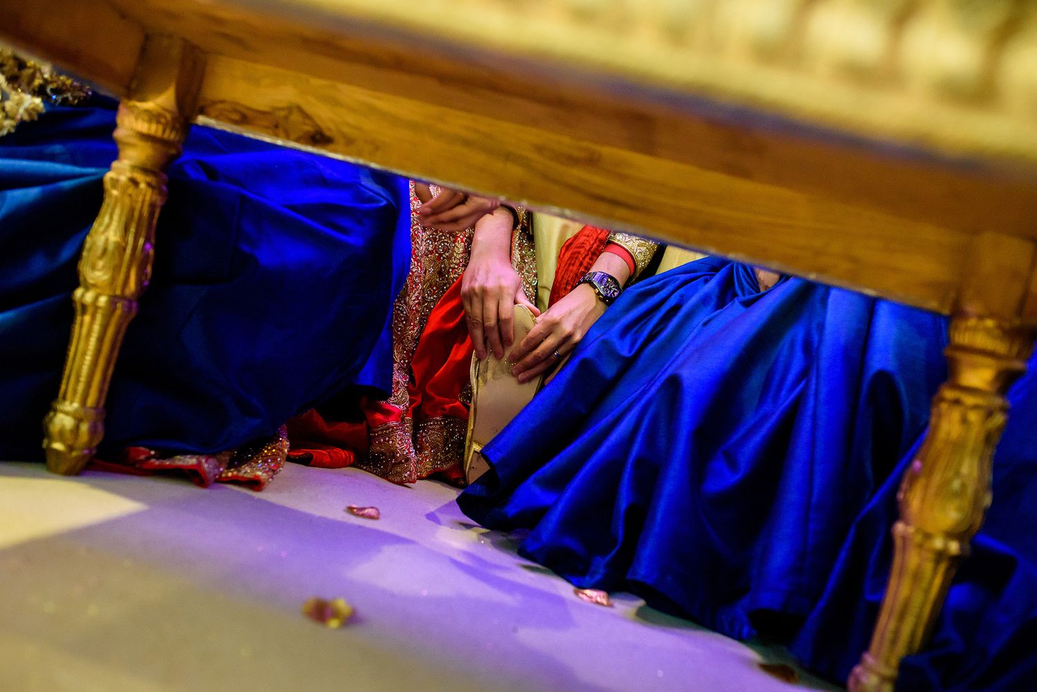 Elegant golden decor and blue fabric details at a formal wedding venue setup.