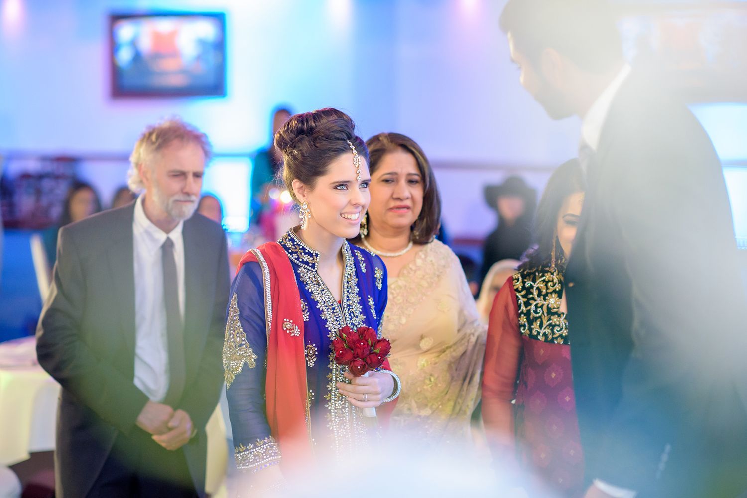 Wedding reception venue with blue lighting and guests enjoying the celebration.