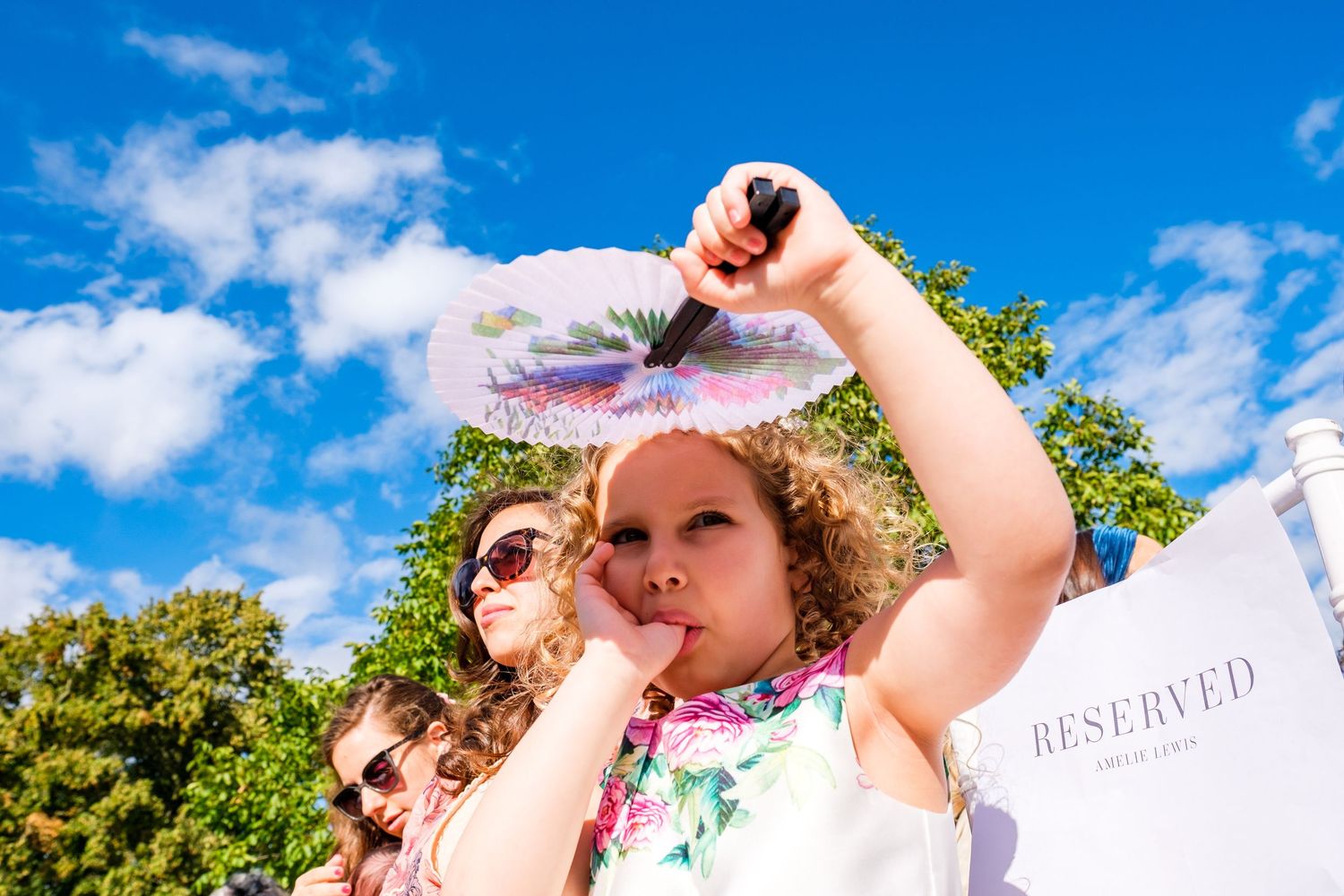 Wedding guests enjoying a sunny outdoor celebration under bright blue skies.