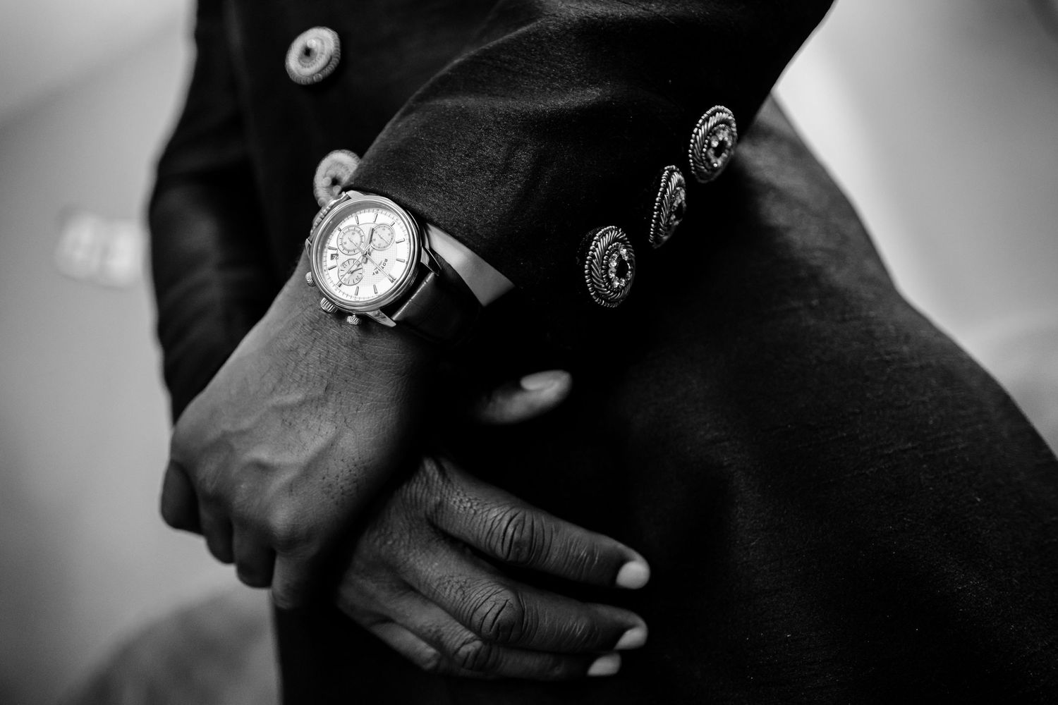 Close-up black and white image showing parts of hands and arms.