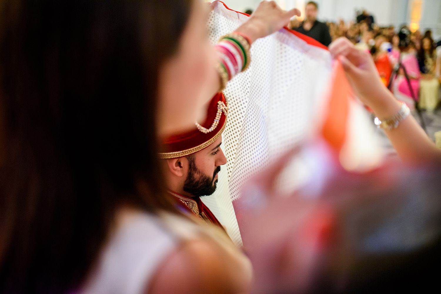 Wedding guests throw flower petals during a joyous celebration at an Indian ceremony.