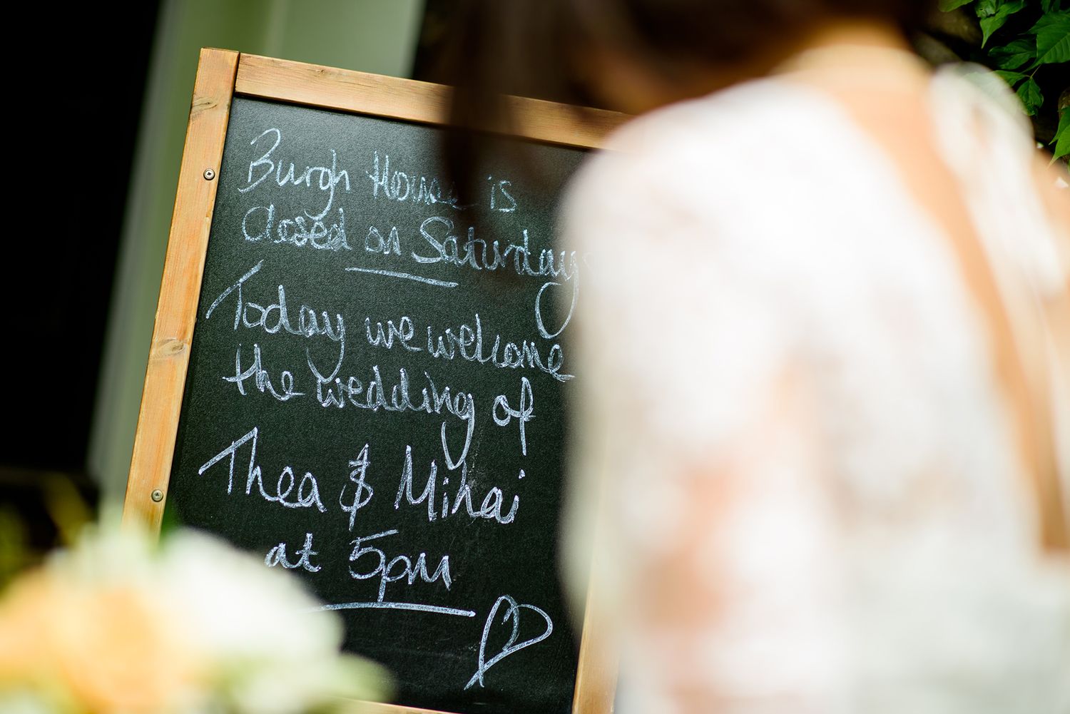Close-up of wedding details written on chalkboard signs with decorative text.