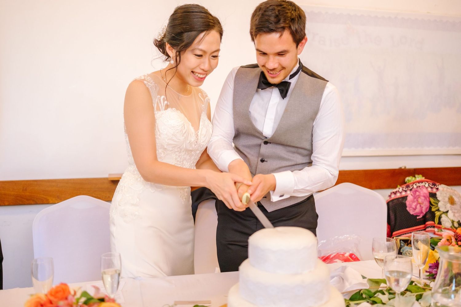 Wedding reception table with couple signing documents during celebration.