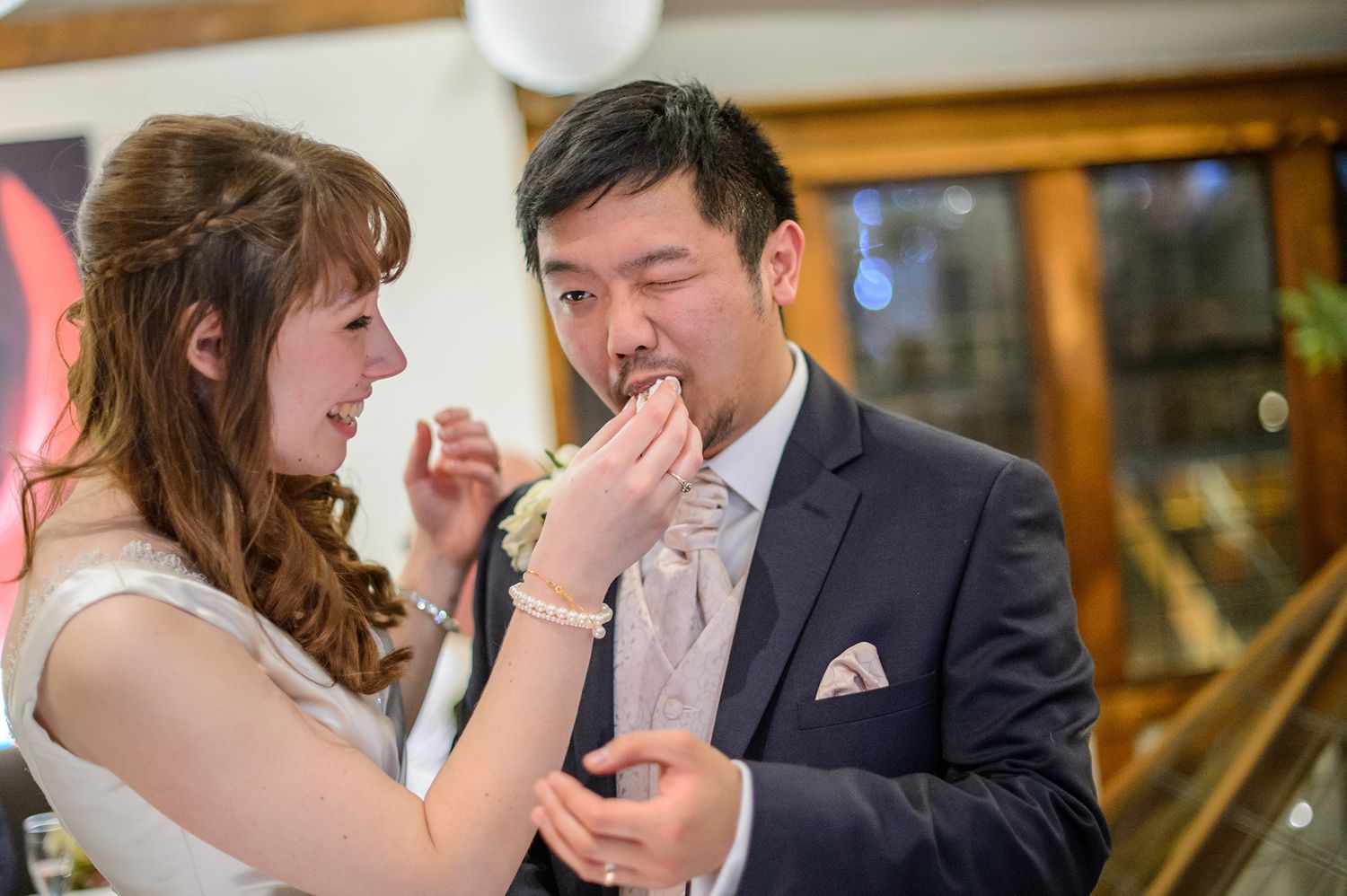 Couple shares intimate moment while dining together at elegant reception venue.