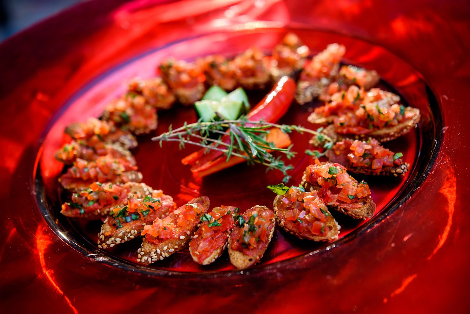 Succulent steaks and appetizers beautifully plated on red-lit tables at an upscale restaurant.