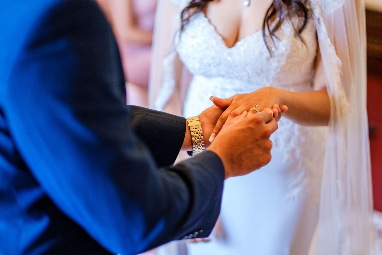 A series of hands exchanging wedding rings during an intimate ceremony moment.