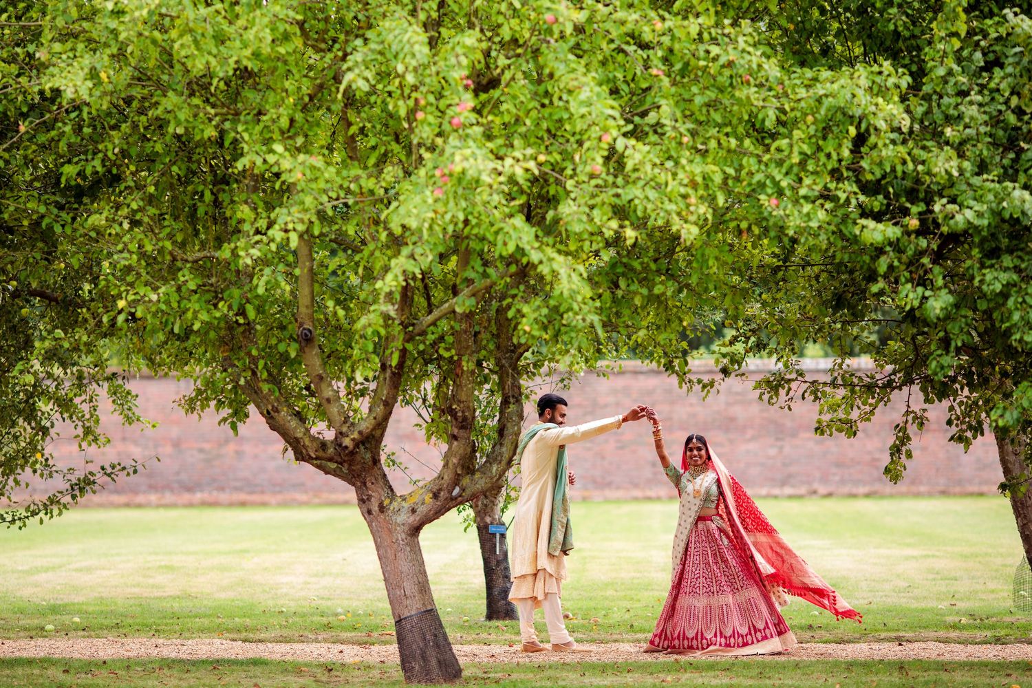 Scenic outdoor wedding photo session in a lush green park setting.