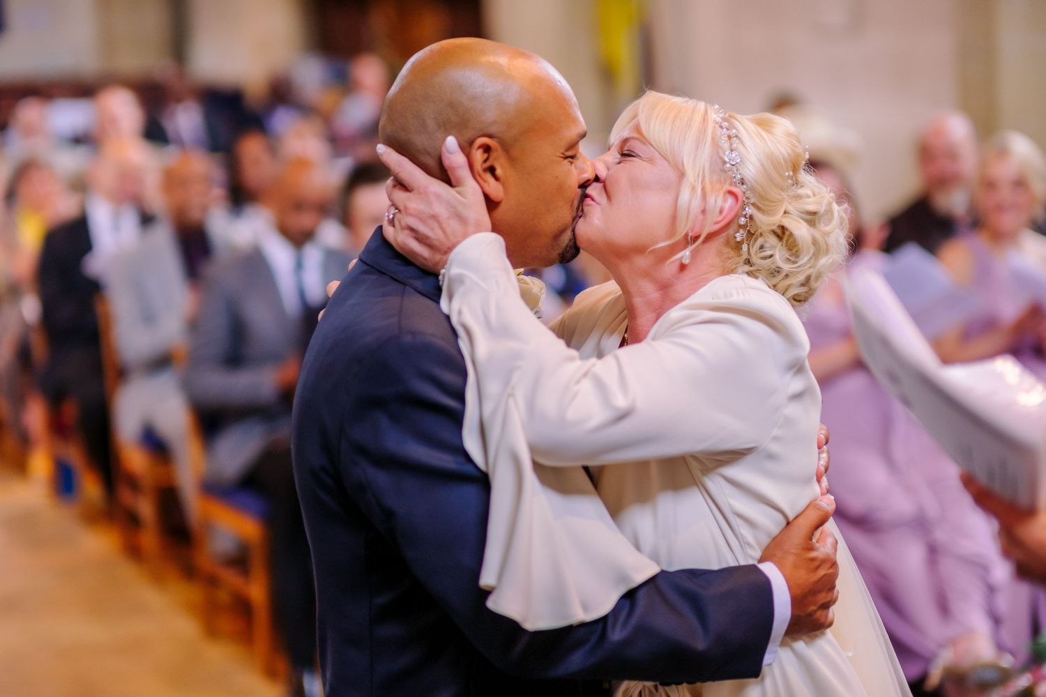 Wedding reception celebration with guests dancing and embracing on a dance floor.
