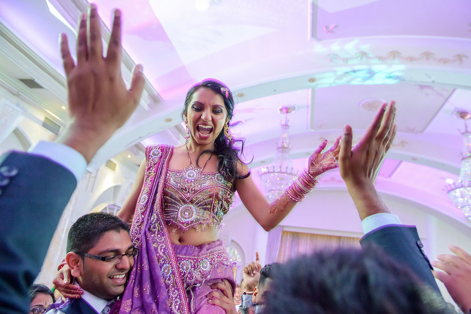 Celebration moment captured during an Indian wedding reception with guests dancing.