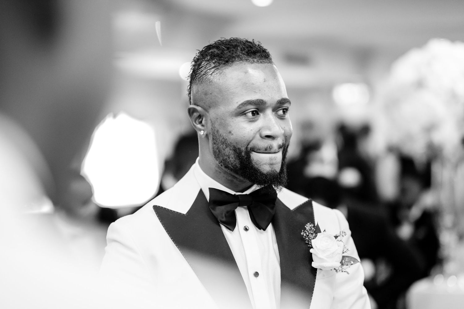Wedding party members share joyful reactions and laughter during an emotional moment at the reception.