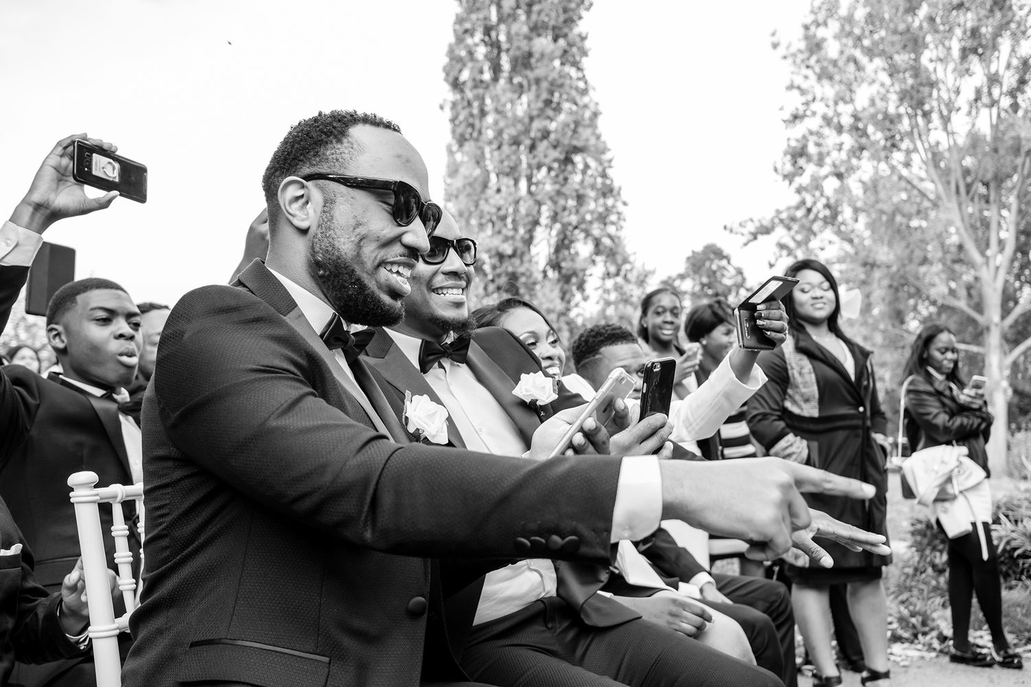 Wedding party members react with joy during outdoor celebration.