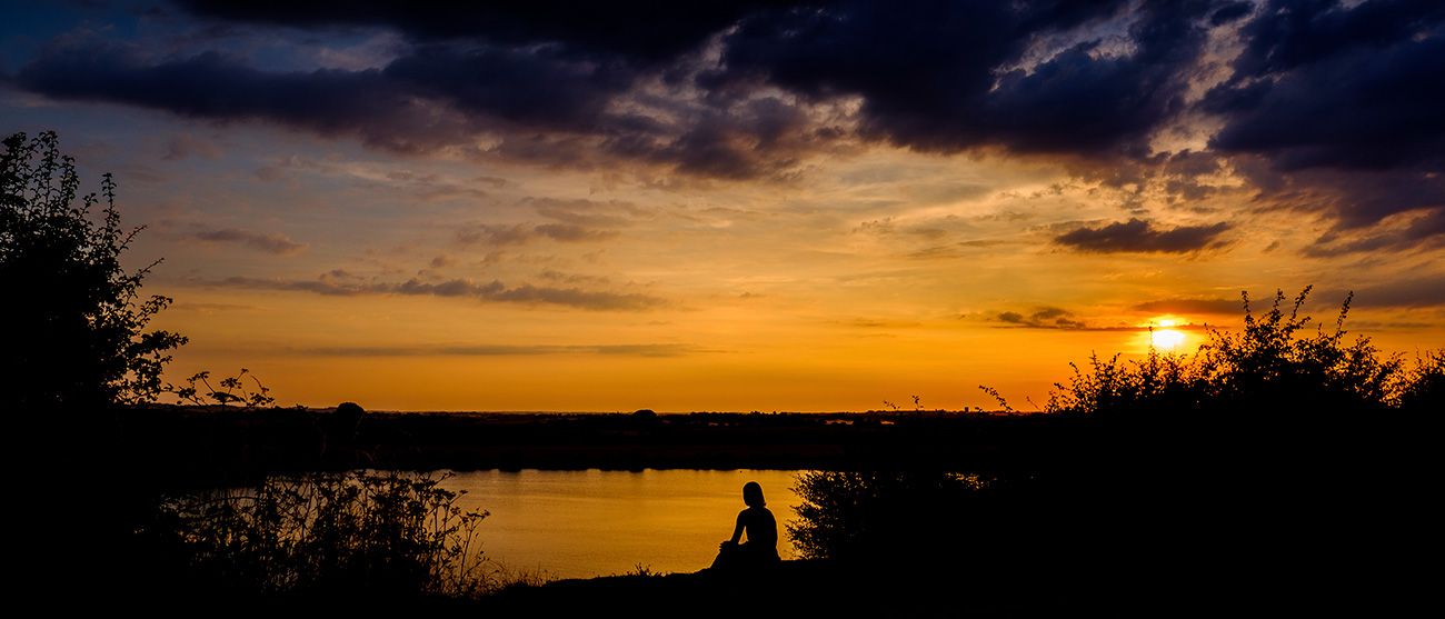 Stunning orange and purple sunset sky with dark silhouettes in the foreground.