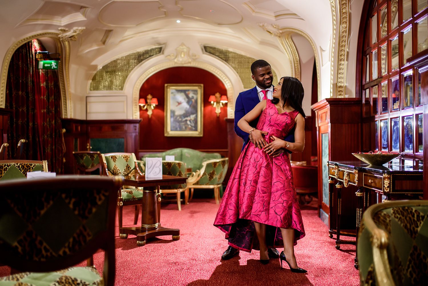 Elegant reception venue with arched ceilings and red carpeting.