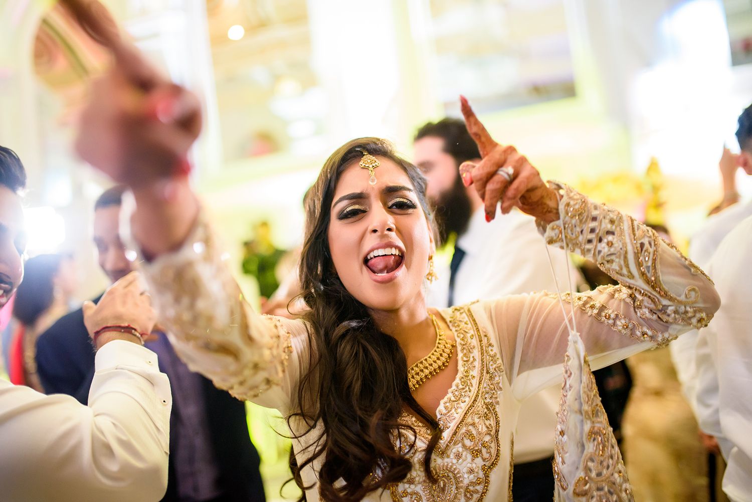 Wedding guests dancing and celebrating together on the dance floor at a glamorous reception party.