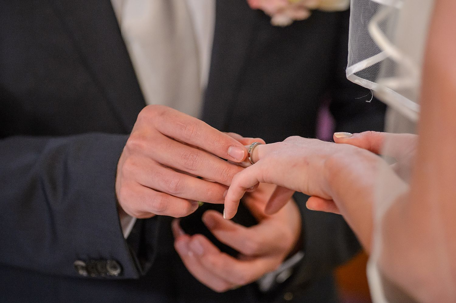 Close-up shots of wedding ring exchange during ceremony.