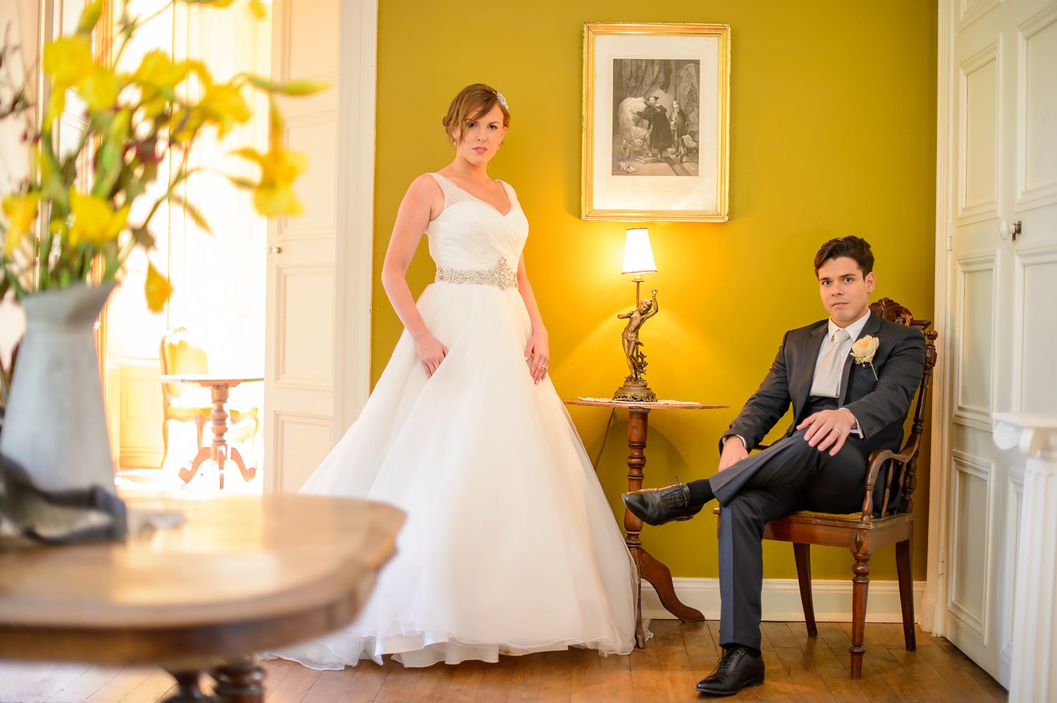 Wedding portraits in a yellow-walled room with classic furnishings.
