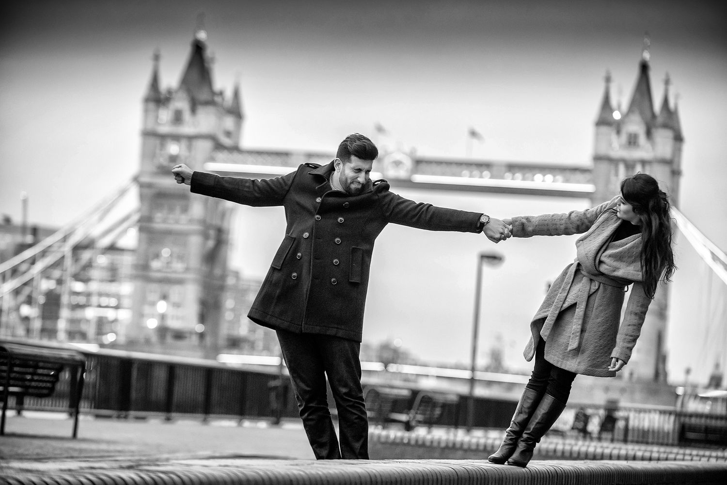 Couple enjoys romantic moment together against iconic London Bridge backdrop at dusk.