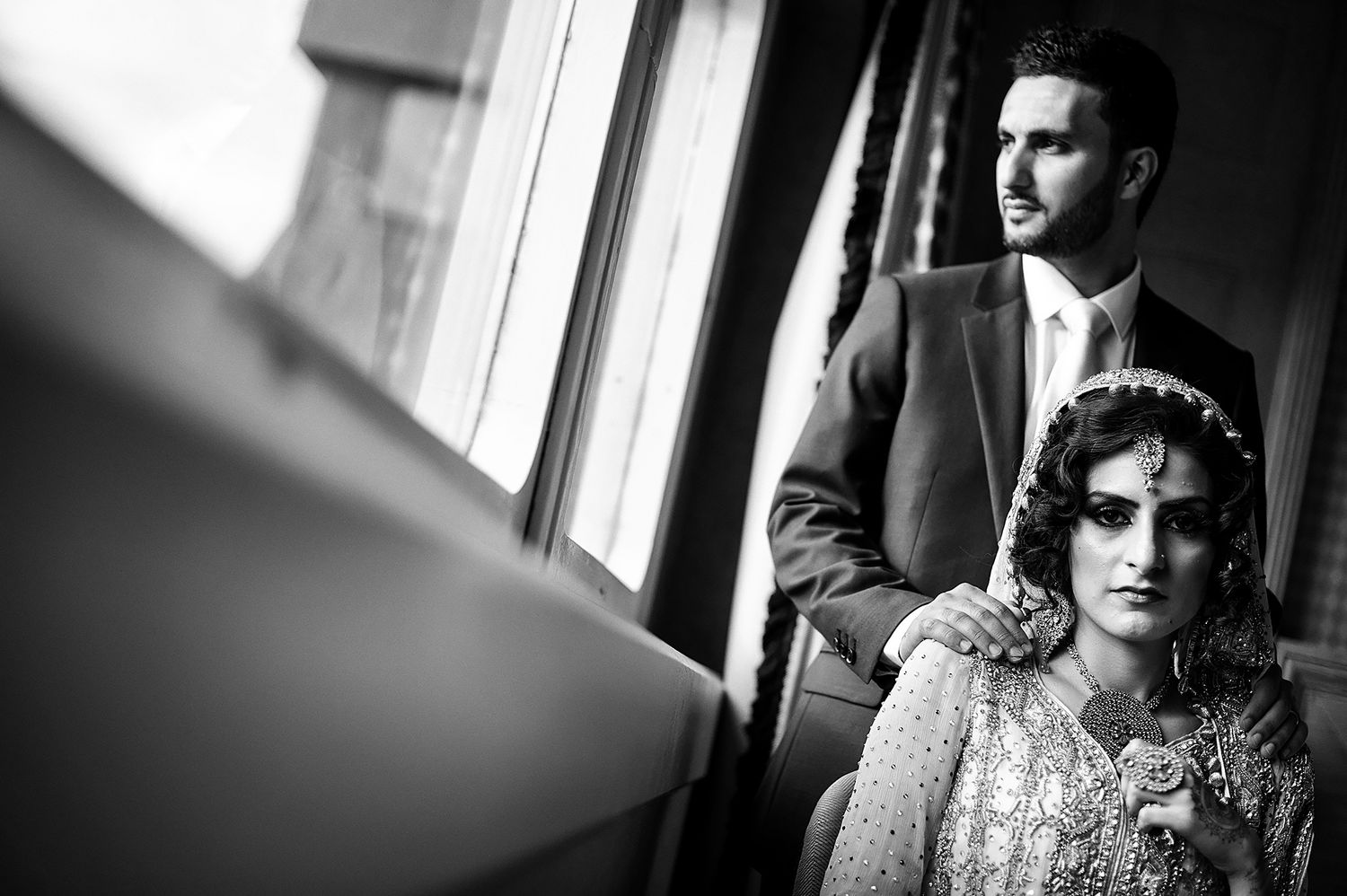 Dramatic black and white wedding portraits in window light.