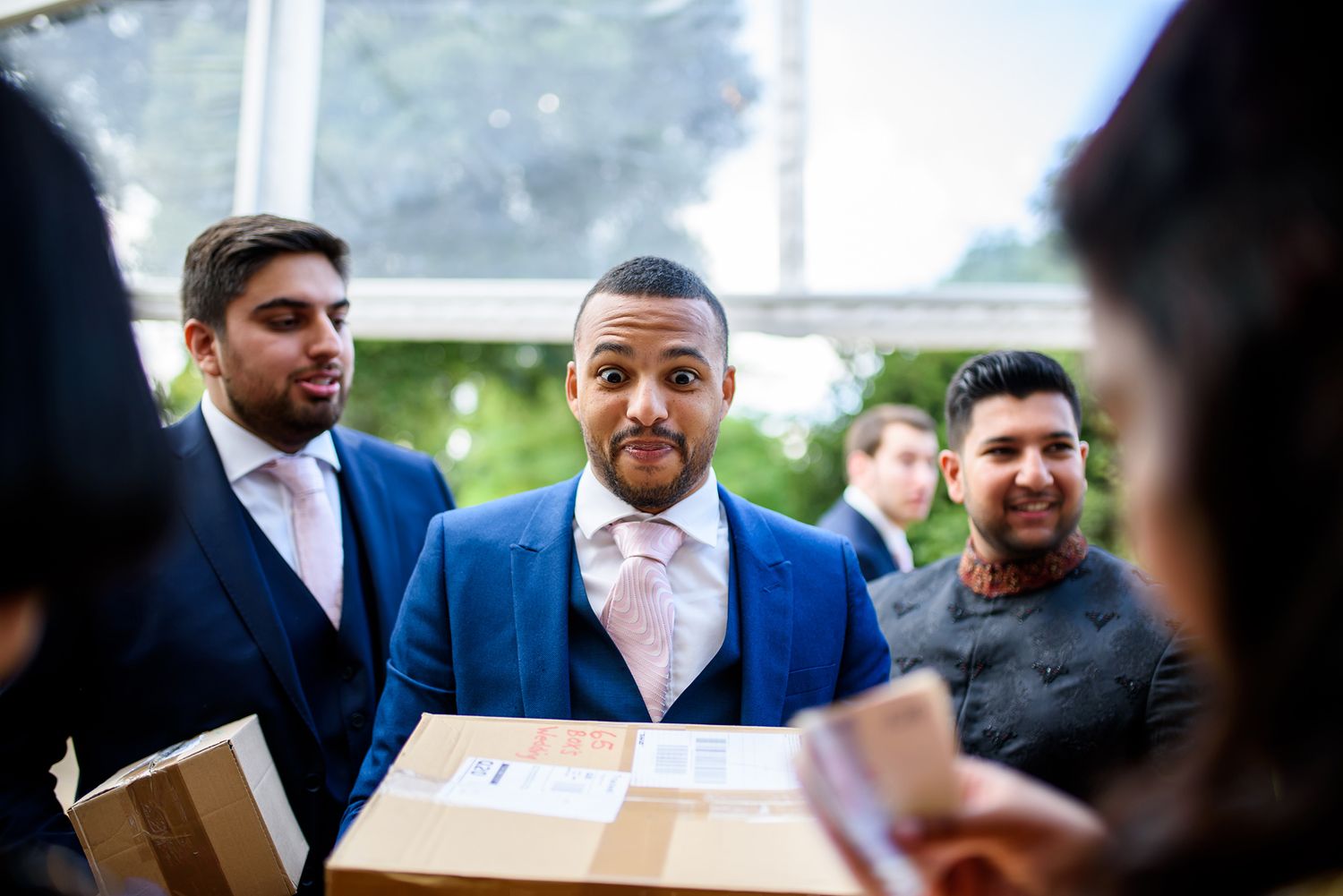 Group of wedding guests gathered outdoors in formal attire for a celebration.