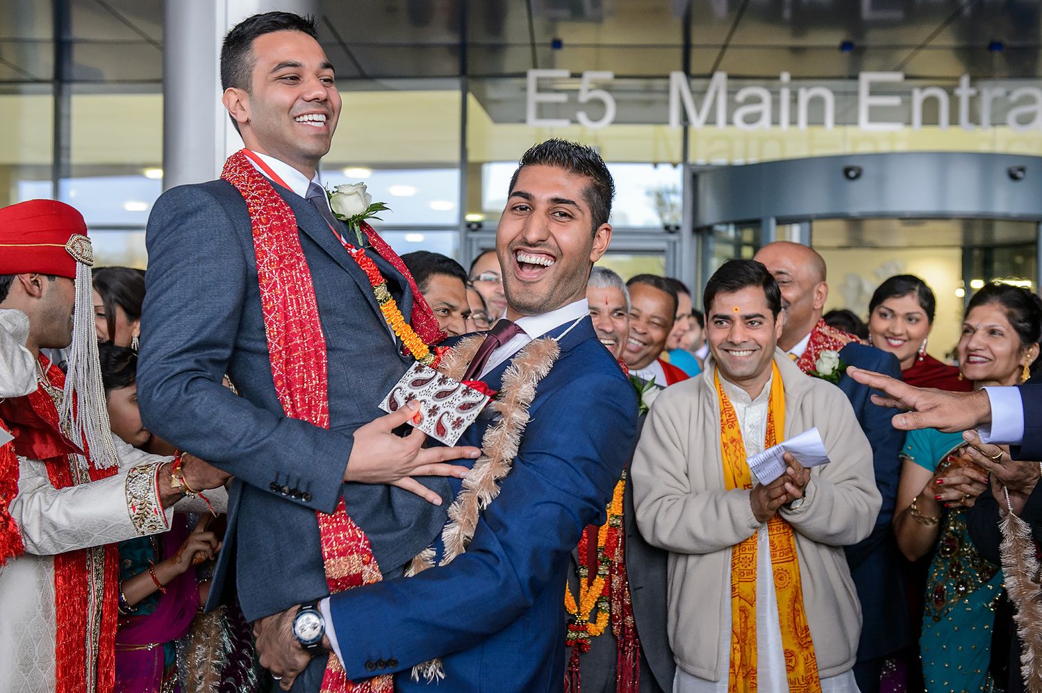 Lively celebration with wedding guests dancing and enjoying festivities in formal attire.
