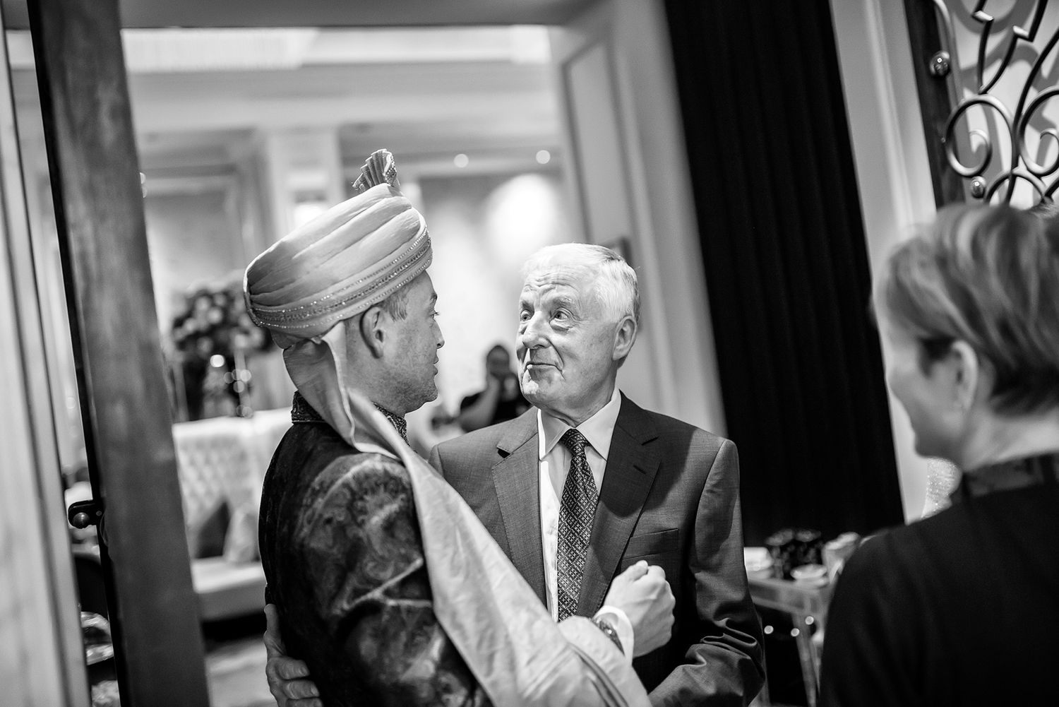 Guests celebrating during a festive wedding reception in an ornate indoor venue.
