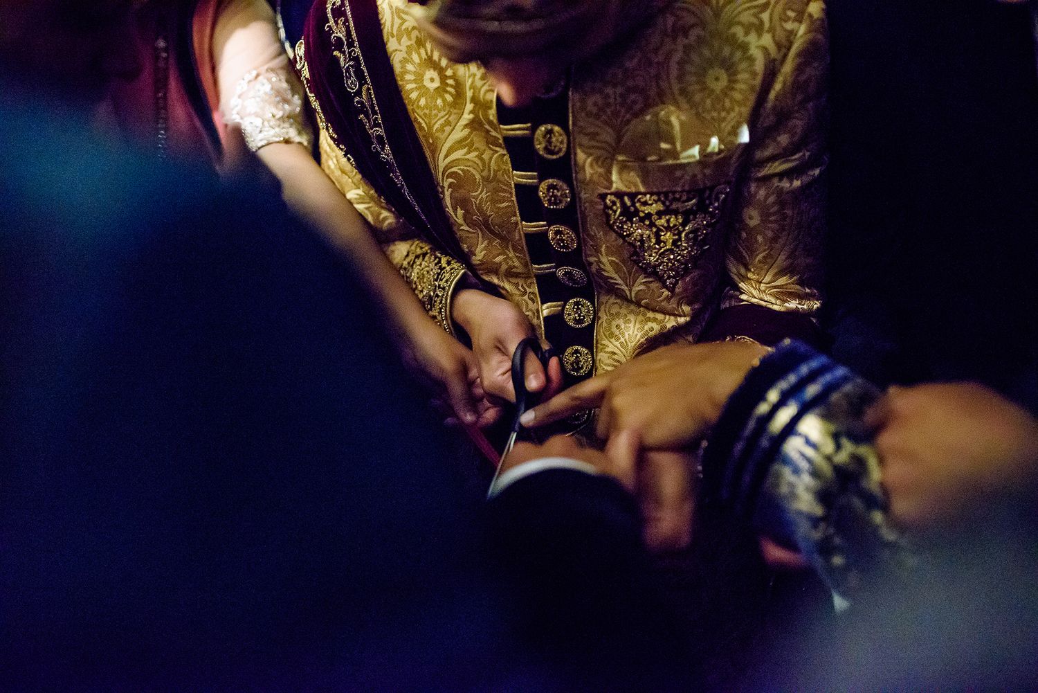 Close-up of intricate traditional wedding jewelry and garments in dramatic lighting.