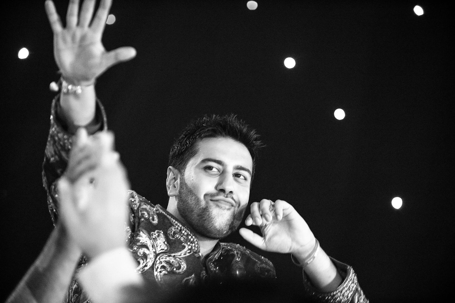 Dramatic black and white portrait of performer against starlit background.