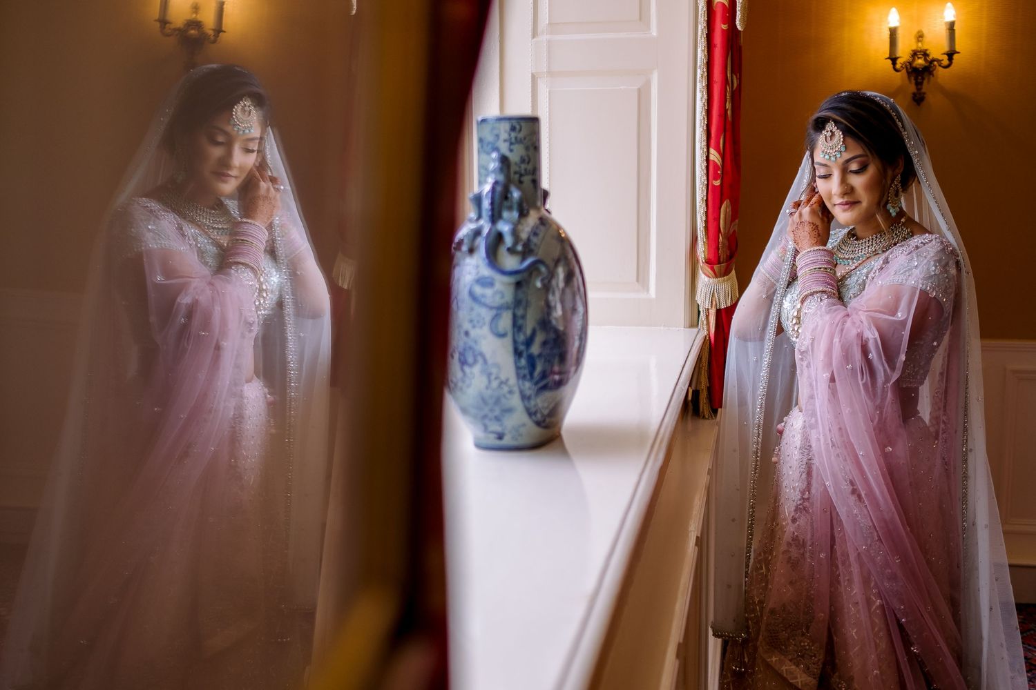 Bride in pink traditional dress getting ready in elegant room with warm lighting.
