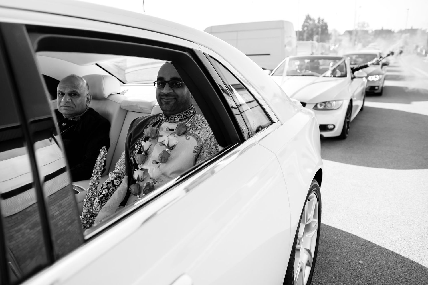 Black and white photo of passengers inside a car looking out through the windows during a journey.