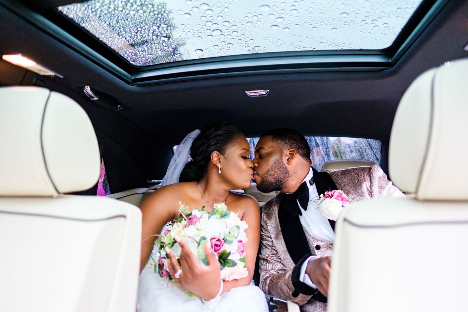 View through car sunroof during wedding transportation on rainy day.