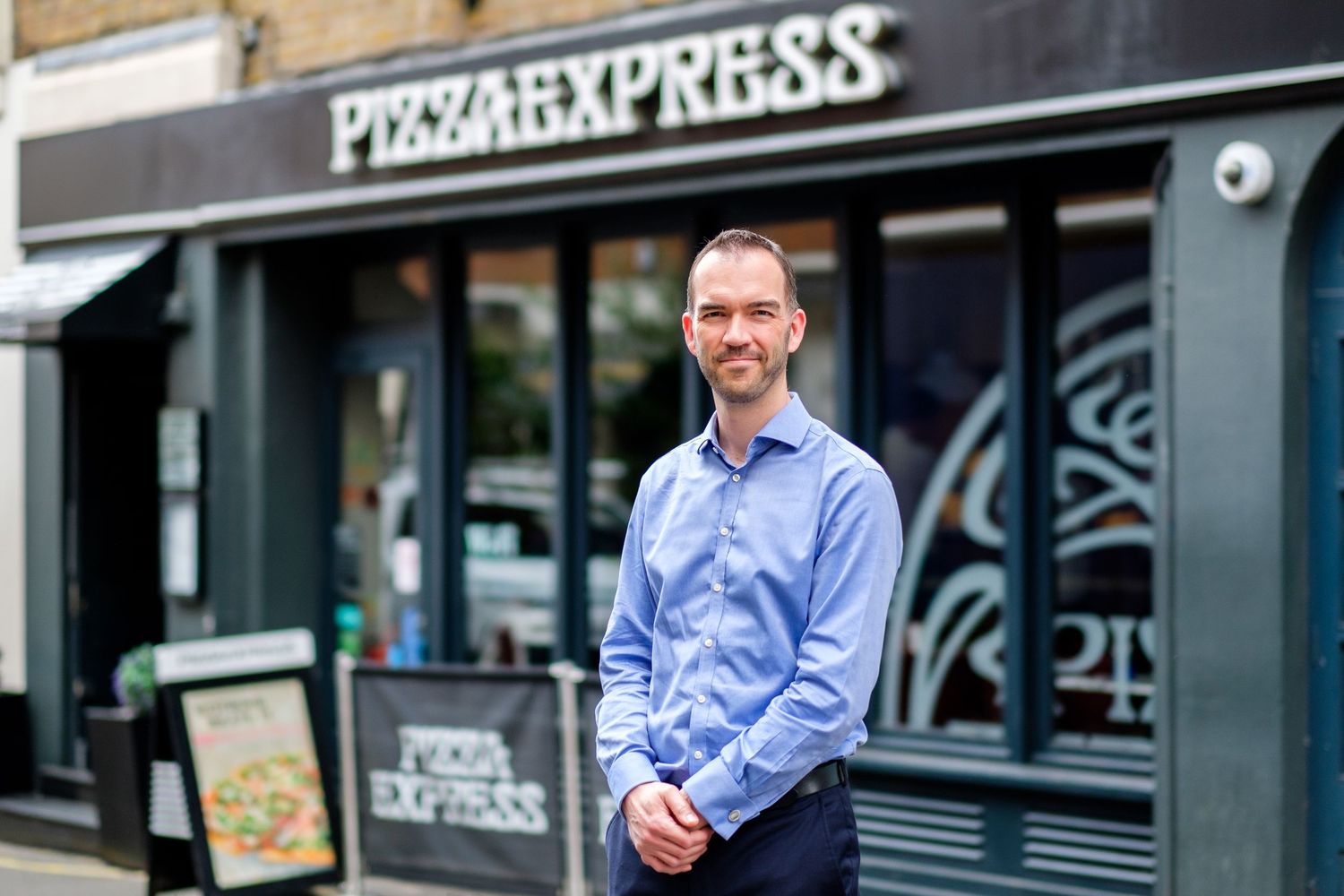Pizza Express restaurant exterior with blue and white branded signage.