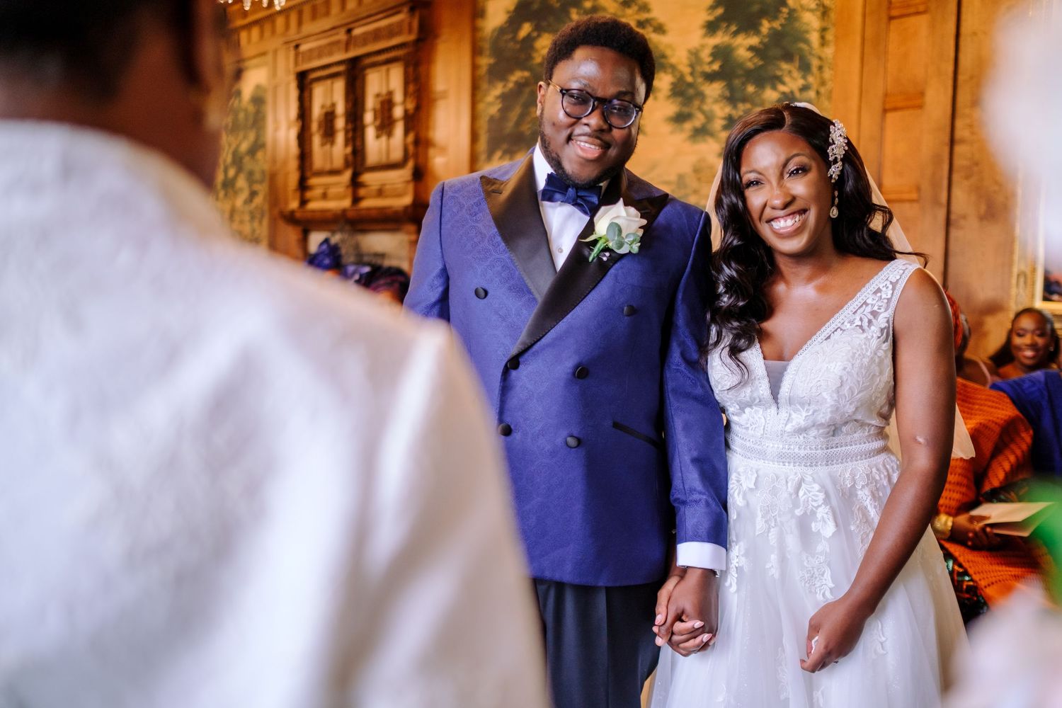 A couple shares a joyful moment during their wedding ceremony in an elegantly decorated indoor venue.